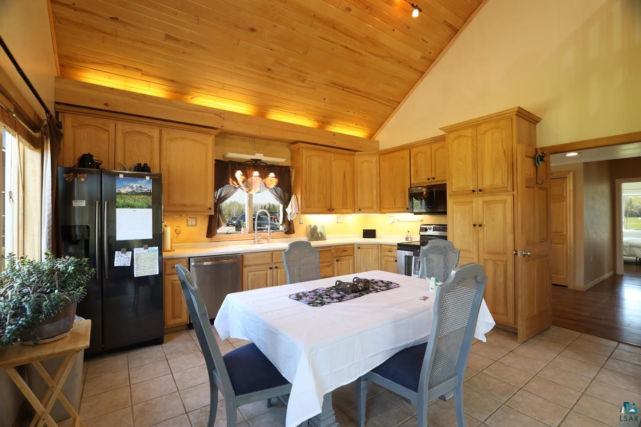 10362 Arkola Road Meadowlands, MN 55765 - Photo 7 of 30 Kitchen with stainless steel appliances, wooden ceiling, a sink, light tile patterned floors, and light countertops