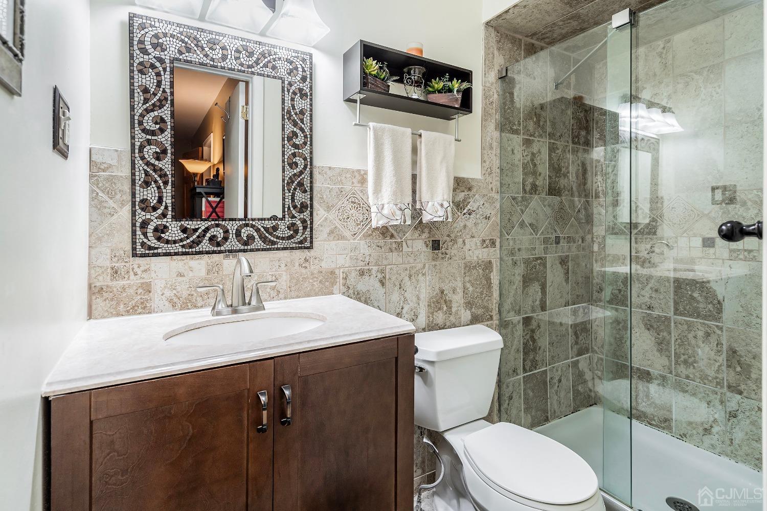 606 Robin Road Hillsborough, NJ 08844 - Photo 15 of 20 a bathroom with a toilet a sink a shower and mirror