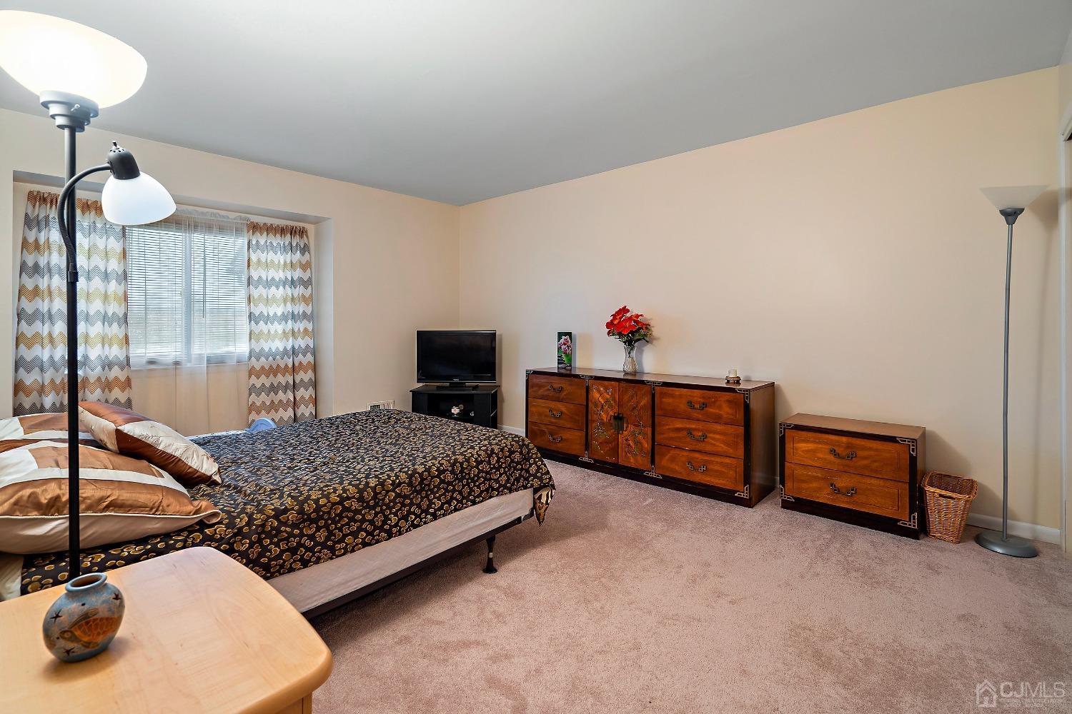 606 Robin Road Hillsborough, NJ 08844 - Photo 16 of 20 a bedroom with bed and a chandelier