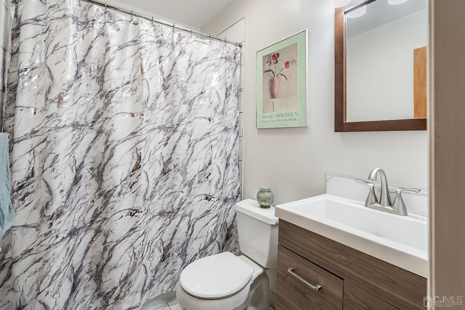 606 Robin Road Hillsborough, NJ 08844 - Photo 17 of 20 a bathroom with a toilet sink and mirror