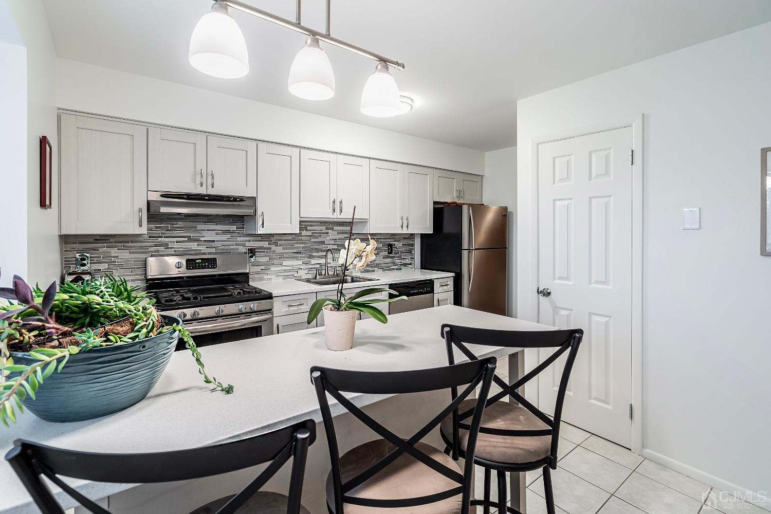 606 Robin Road Hillsborough, NJ 08844 - Photo 5 of 20 a kitchen with a dining table and chairs
