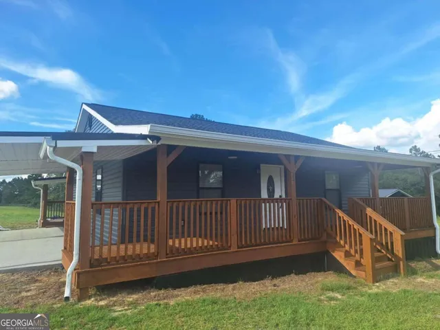 a view of a house with wooden deck front of house