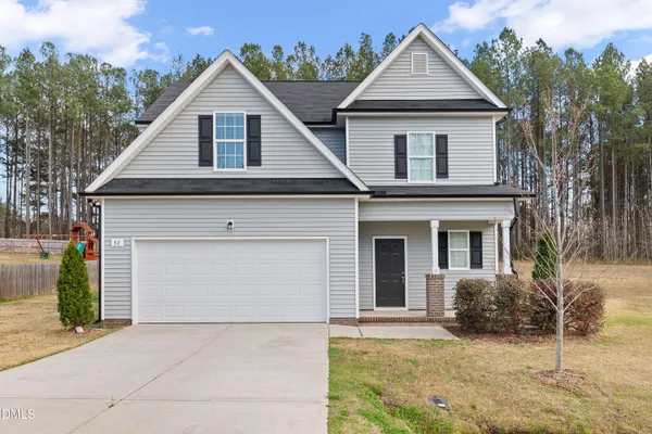 a view of a house with a yard and large tree