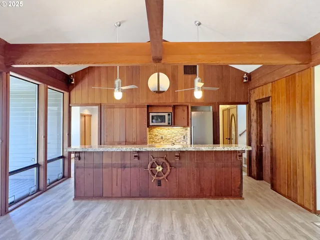 a bathroom with a granite countertop sink a mirror and a shower