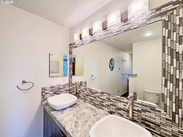 a bathroom with a granite countertop bathtub shower sink and vanity