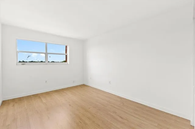 a view of a room with wooden floor and a window