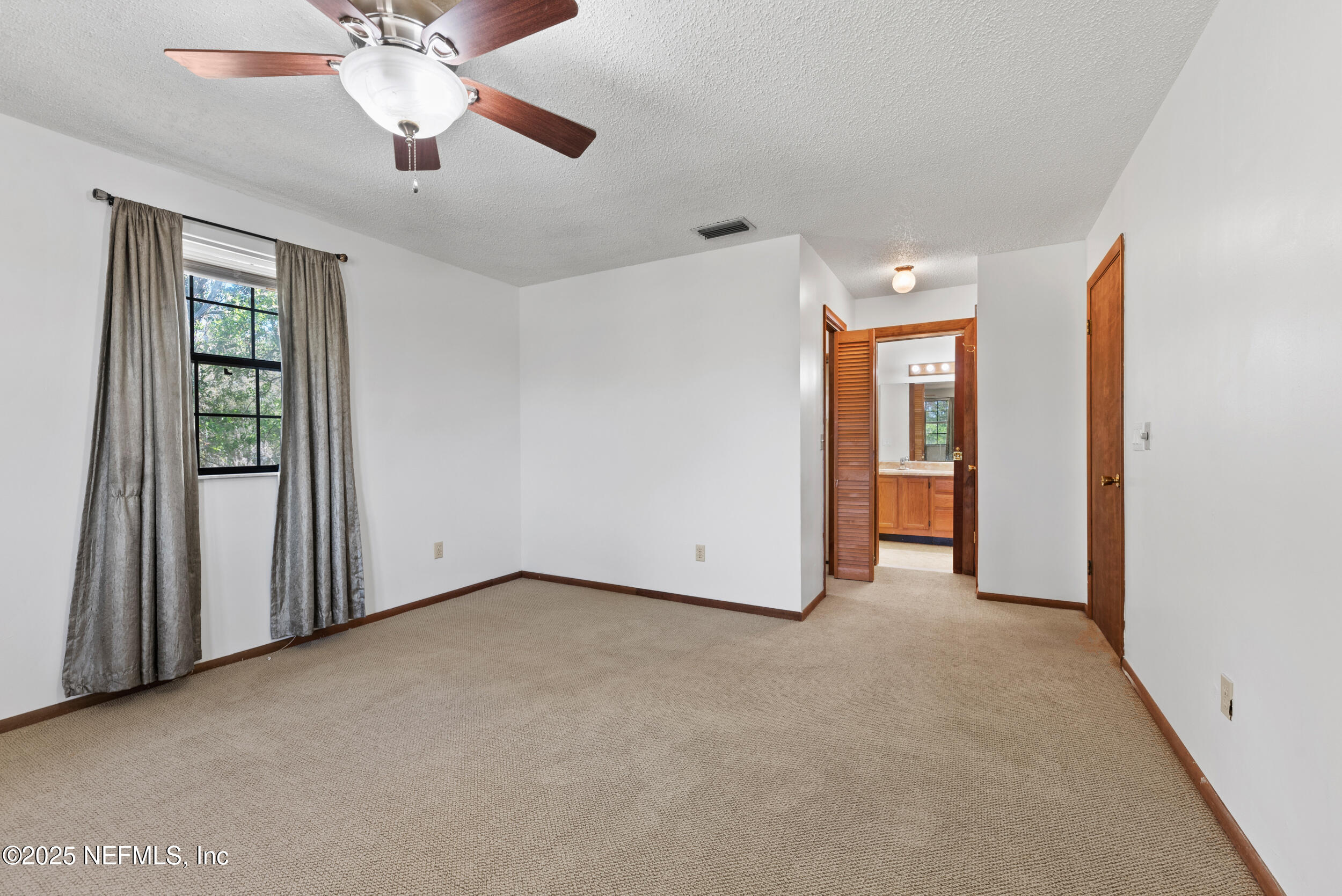 2357 Davis Road Jacksonville, FL 32218 - Photo 15 of 28 an empty room with chandelier fan and windows
