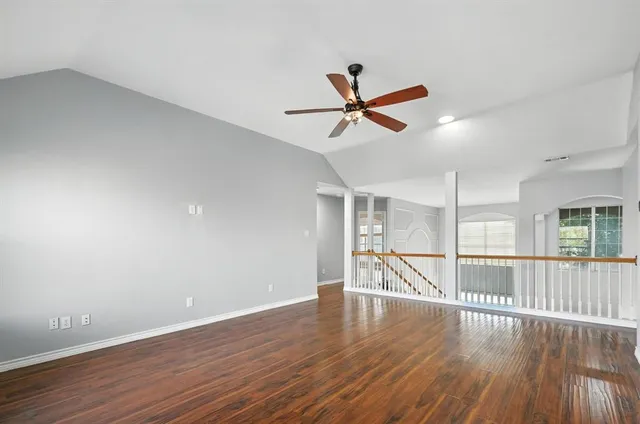a view of a room with wooden floor and ceiling fan
