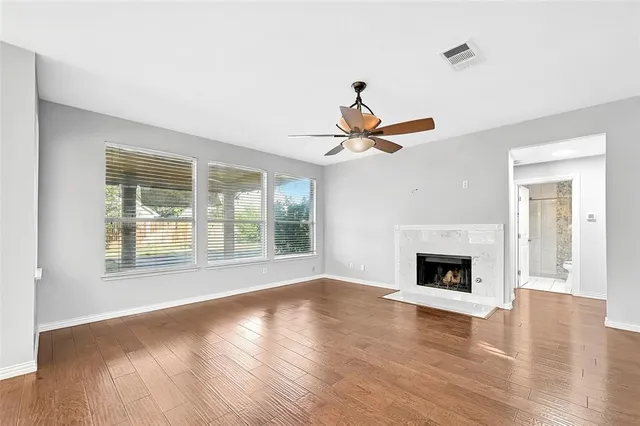 a view of a livingroom with wooden floor and a fireplace