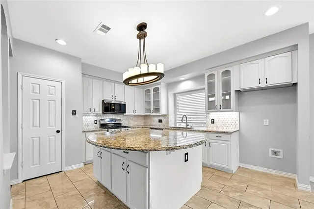 a kitchen with stainless steel appliances granite countertop a sink and a stove