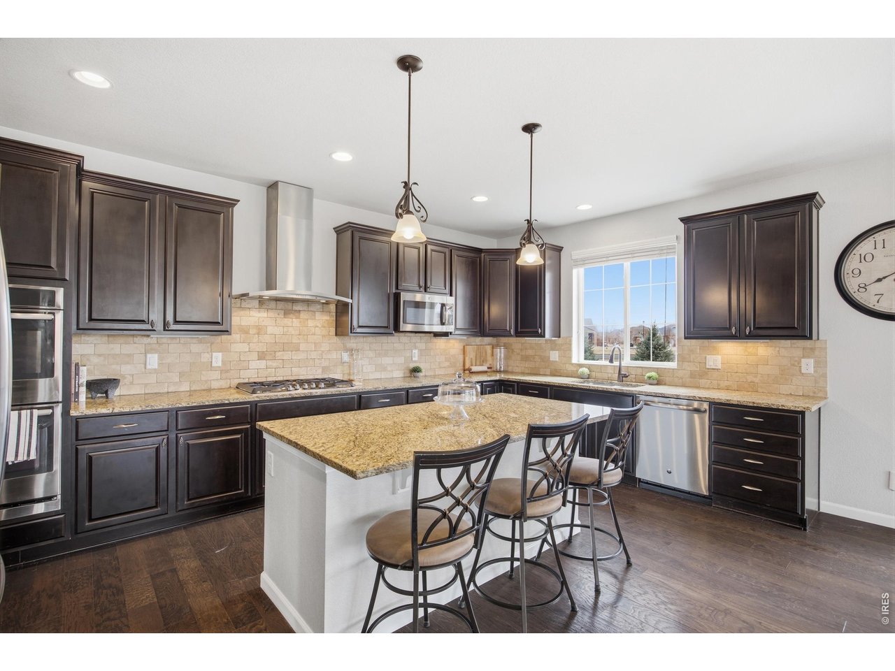 9033 Foxfire Street Firestone, CO 80504 - Photo 11 of 44 a kitchen with stainless steel appliances granite countertop a stove top oven a sink a dining table and chairs