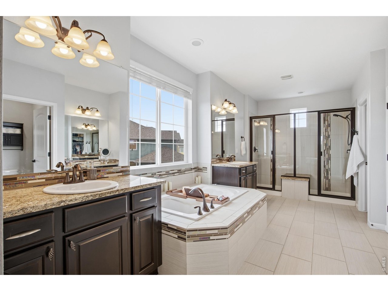 9033 Foxfire Street Firestone, CO 80504 - Photo 24 of 44 a bathroom with a sink double vanity mirror and a bathtub