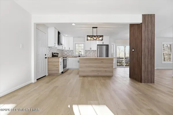 a kitchen with a sink a stove a refrigerator and white cabinets