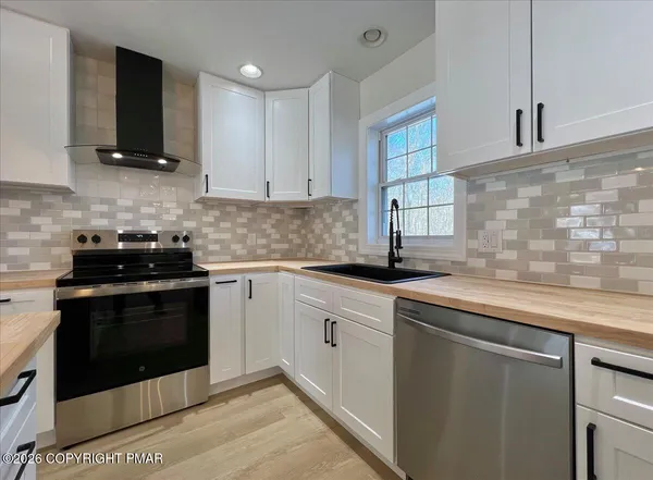 a view of kitchen with stainless steel appliances refrigerator oven and cabinets