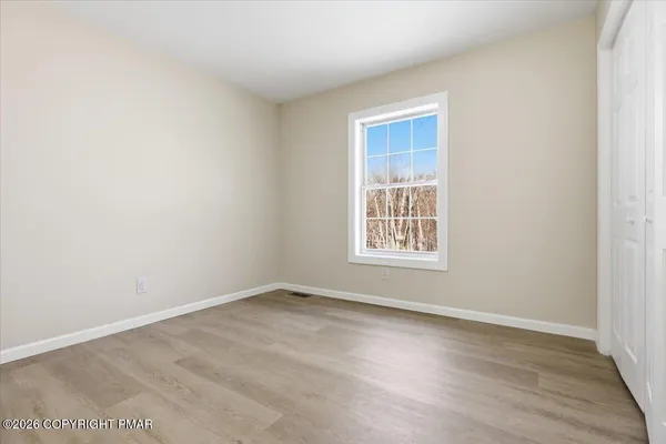 a spacious bedroom with a bed a couch and a large window
