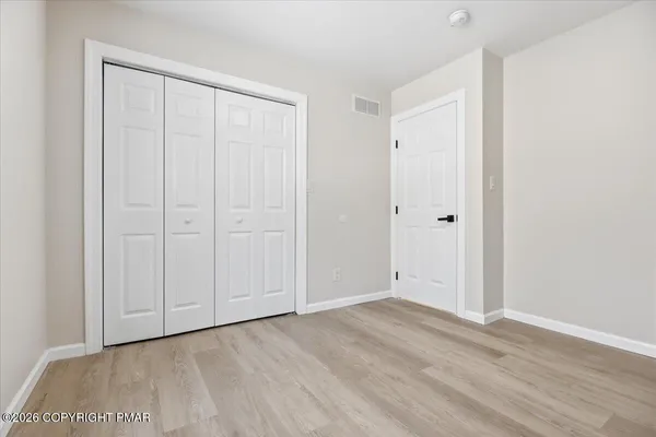 a view of an empty room with wooden floor