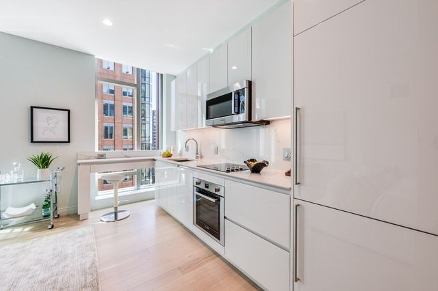 a kitchen with stainless steel appliances a stove refrigerator and microwave