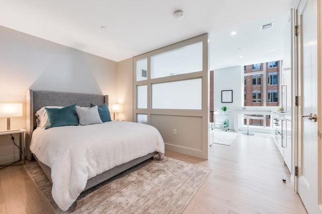 a large bed sitting in a bedroom next to a window