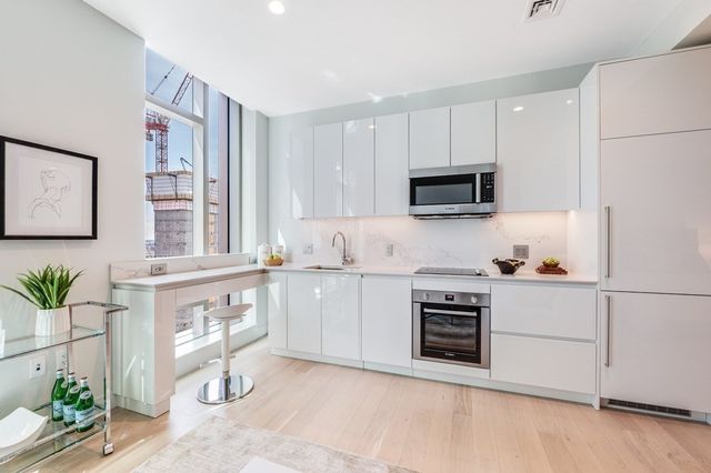 a kitchen with granite countertop white cabinets and black stainless steel appliances