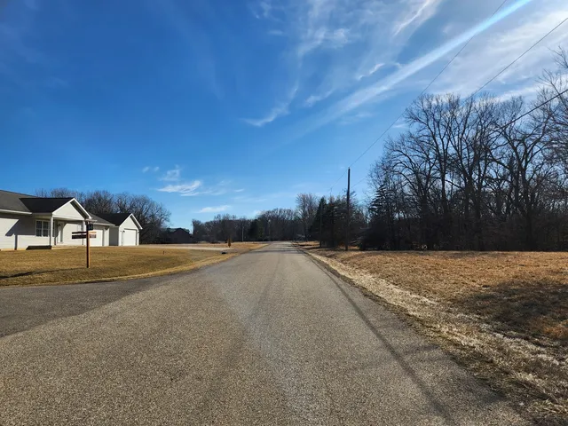 a view of an house with backyard and road