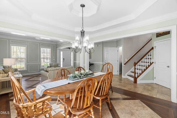 a dining room with furniture a chandelier and wooden floor