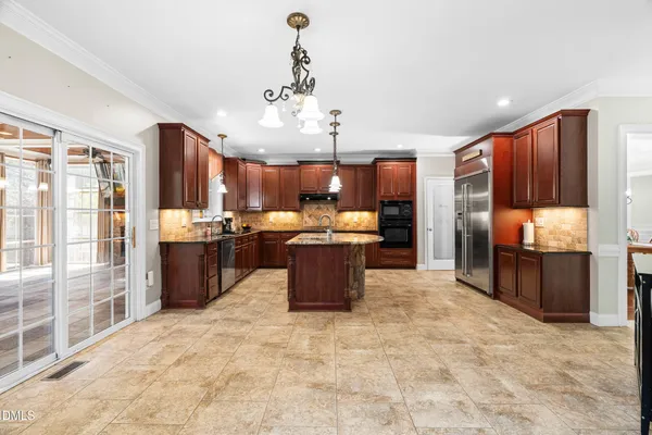 a kitchen with kitchen island granite countertop a sink counter top space appliances and cabinets