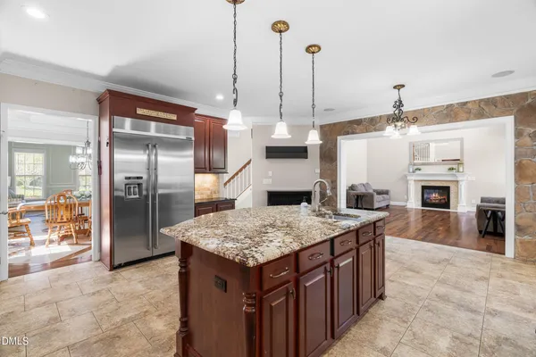a large kitchen with kitchen island a stove a sink a counter top space and living room view