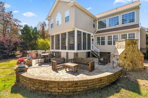 a backyard of a house with barbeque oven table and chairs