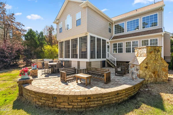 a backyard of a house with barbeque oven table and chairs