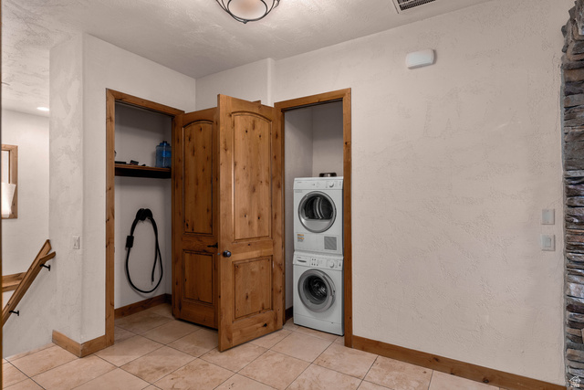 2464 East Granite Way St. George, UT 84790 - Photo 59 of 106 Garage mudroom/foyer with laundry area with stacked washer / dryer and light tile patterned floors