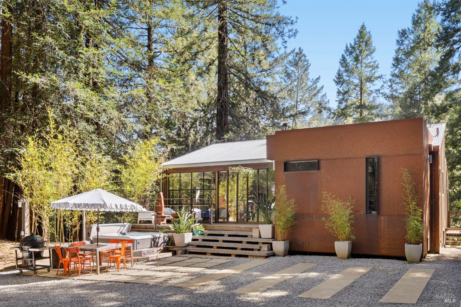 16798 Armstrong Woods Road Guerneville, CA 95446 - Photo 4 of 71 a patio with a table and chairs under an umbrella