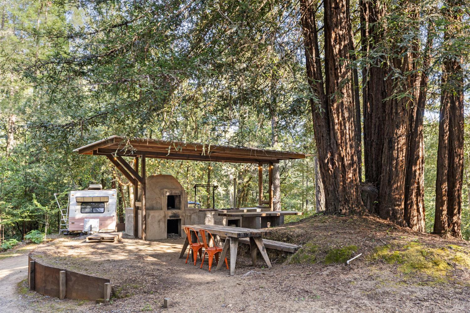 16798 Armstrong Woods Road Guerneville, CA 95446 - Photo 56 of 71 a view of a patio with a table and chairs under an umbrella
