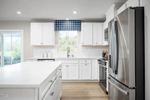 a kitchen with stainless steel appliances a refrigerator sink and cabinets