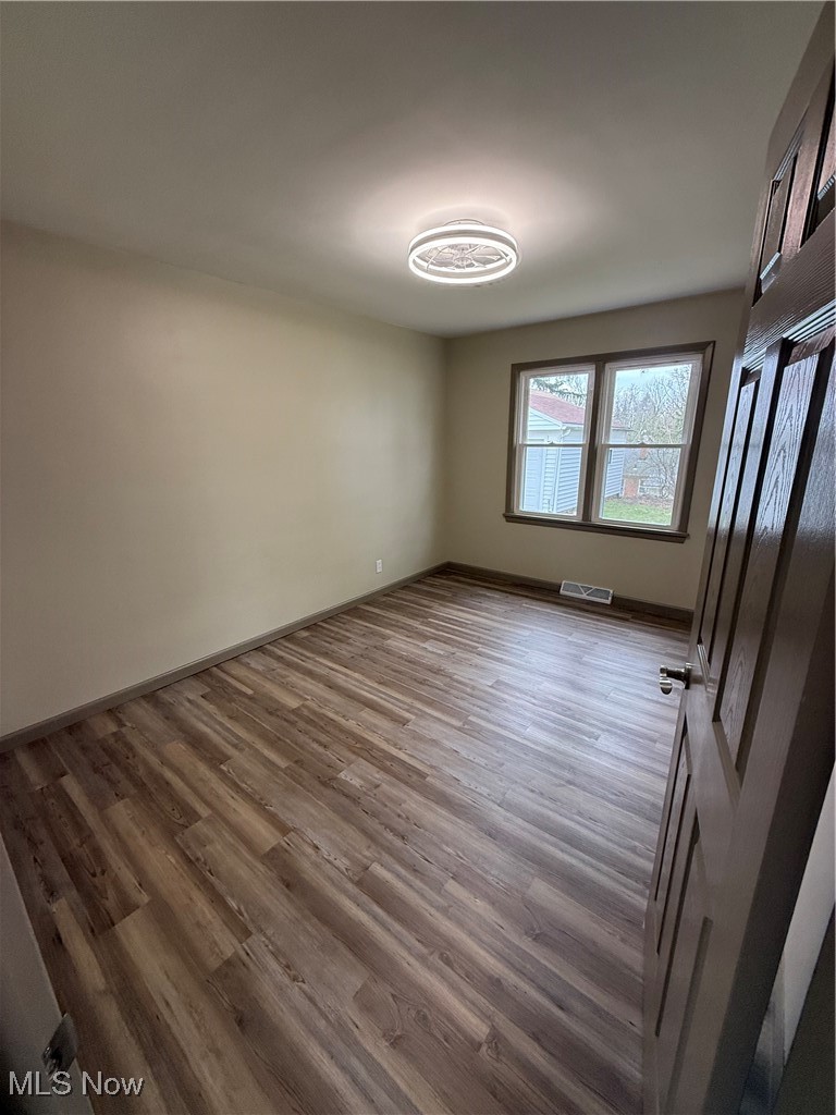 9417 Alexander Road Garfield Heights, OH 44125 - Photo 18 of 38 Unfurnished room with visible vents, baseboards, and wood finished floors