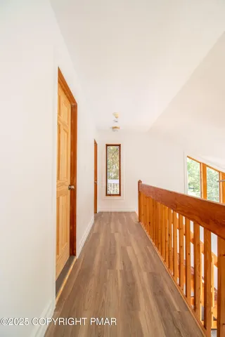 a view of a livingroom with wooden floor and a ceiling fan