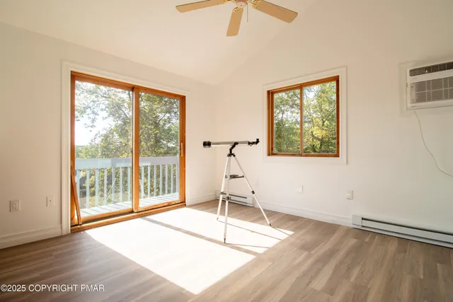 a view of a room with wooden floor and a ceiling fan