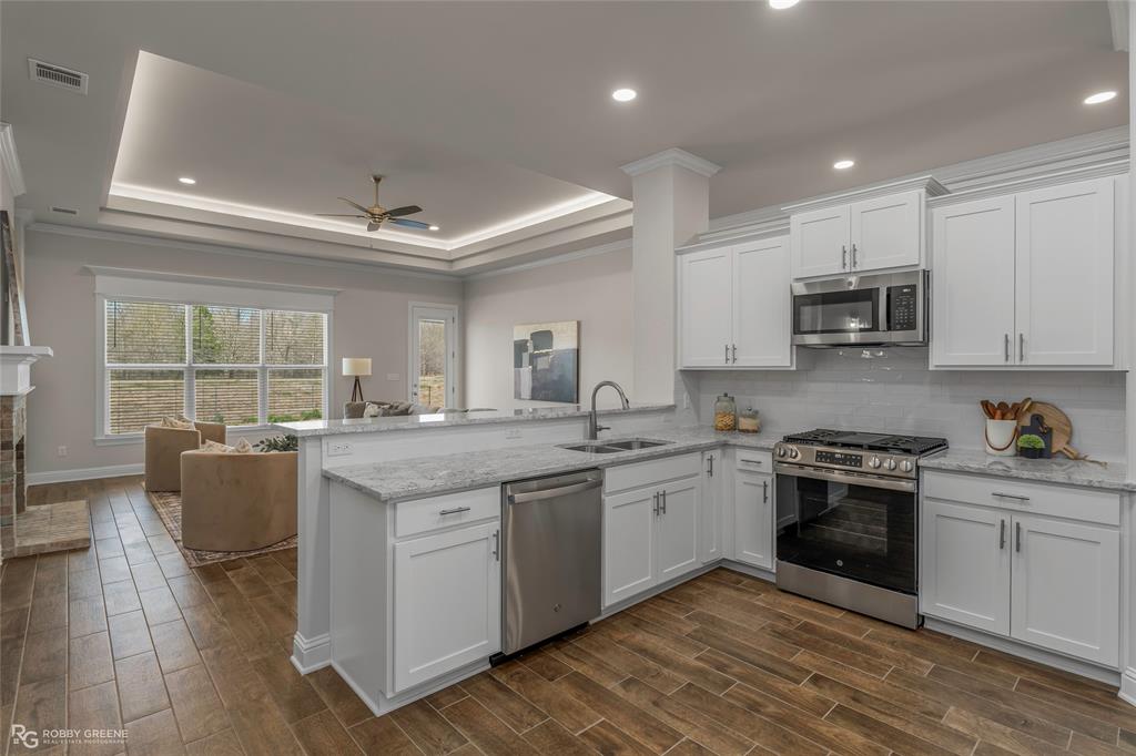 316 Peason Ridge Bossier City, LA 71112 - Photo 3 of 36 a kitchen with granite countertop a stove top oven sink and cabinets