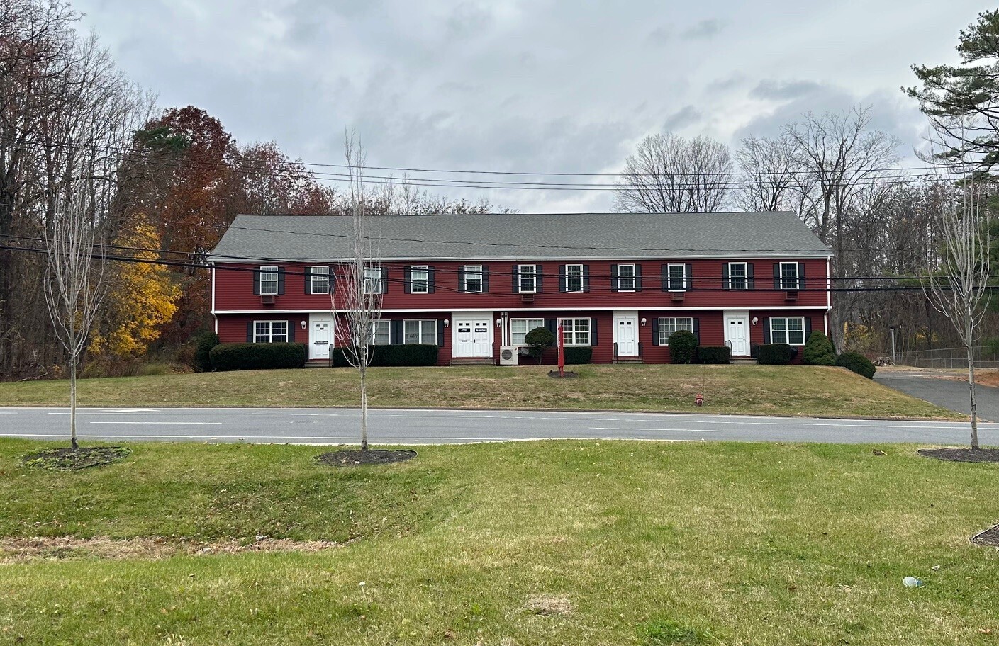 a view of building with a big yard and large trees
