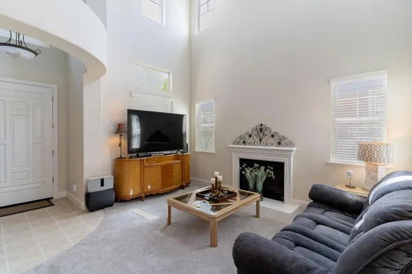 a living room with furniture a flat screen tv and a fireplace
