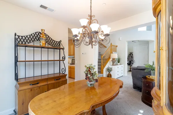 a view of a dining room with furniture and a chandelier
