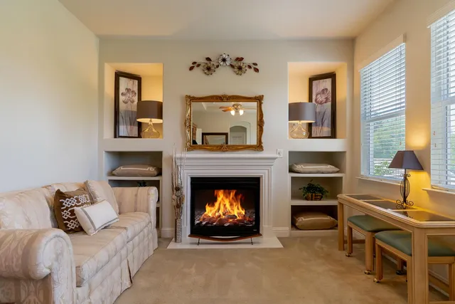 a living room with furniture a fireplace and a window