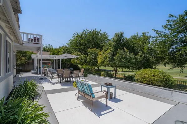 a view of a patio with table and chairs potted plants with wooden floor and fence