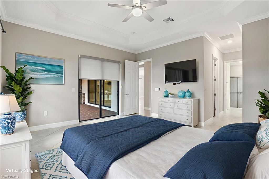 28076 Foxrock Court Bonita Springs, FL 34135 - Photo 24 of 50 Virtually Staged. Primary bedroom featuring crown molding, custom slider shades w/ remote, tile flooring, tray ceiling, access to outside, and ceiling fan w/ light and controls.