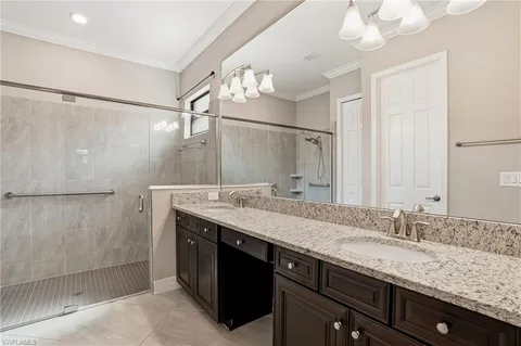 a bathroom with a granite countertop sink a mirror and a shower