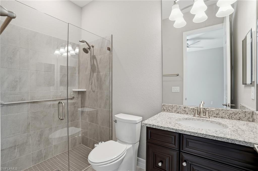 28076 Foxrock Court Bonita Springs, FL 34135 - Photo 31 of 50 Bathroom in bedroom #2, features walk in shower with custom glass enclosure, designer cabinets, quarts countertops, under mount sink, custom mirrors with lighting.