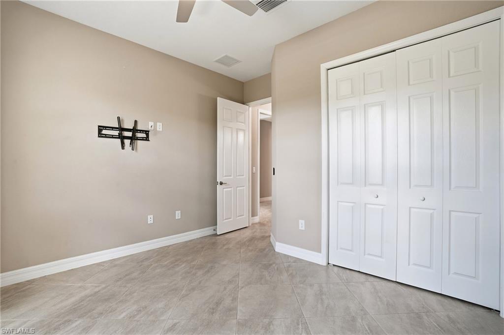 28076 Foxrock Court Bonita Springs, FL 34135 - Photo 32 of 50 Unfurnished bedroom #3, featuring a ceiling fan, closet, window blinds and tile flooring.
