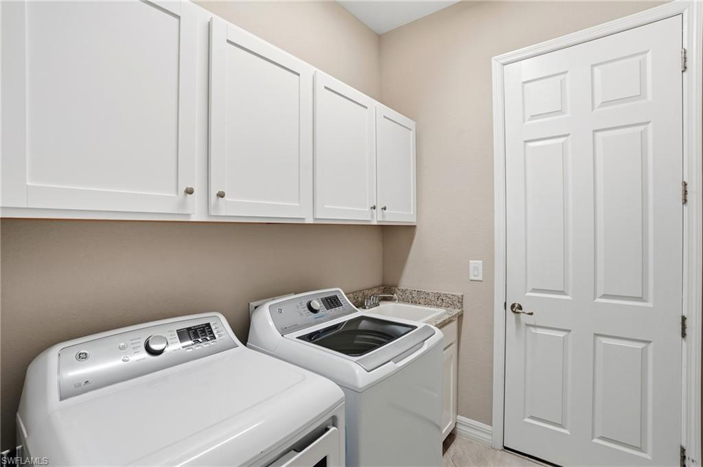28076 Foxrock Court Bonita Springs, FL 34135 - Photo 37 of 50 Laundry area featuring independent washer and dryer, above cabinets and built-in laundry sink with storage.