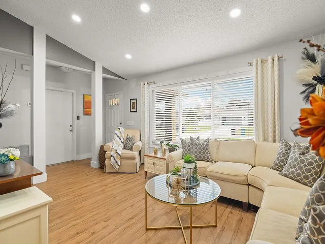a living room with furniture and a wooden floor