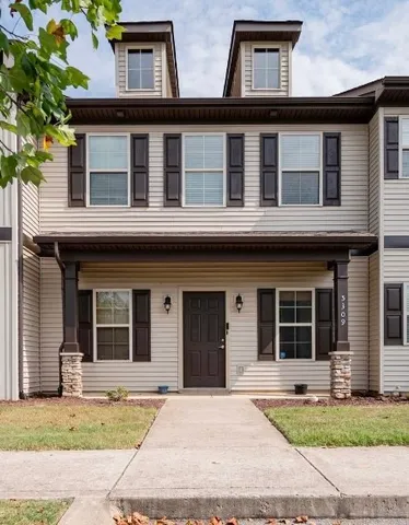 a house that has lot of windows and plants in front of it