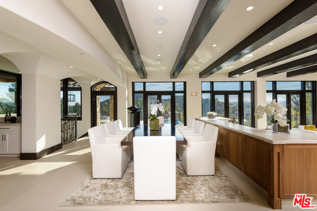 2175 Summitridge Drive Beverly Hills, CA 90210 - Photo 14 of 51 a dining room with wooden floor and chandelier